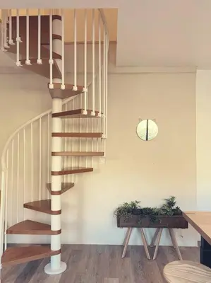 a spiral staircase in a living room with a table at Maison de campagne dans un domaine viticole in Tautavel