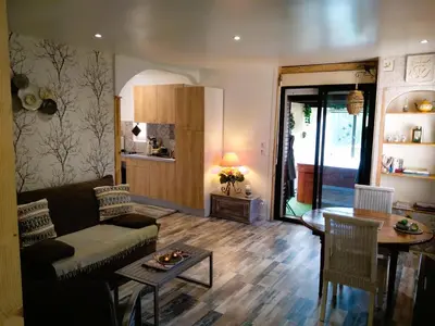 a living room with a couch and a table at Gîte en pleine nature - Parc, Piscine, Jacuzzi in Brézilhac
