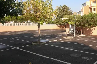 a parking lot with a tree in the middle at Gruissan (Aude) Appartement calme, vue sur port de plaisance -Clim, Empl.Parking in Gruissan
