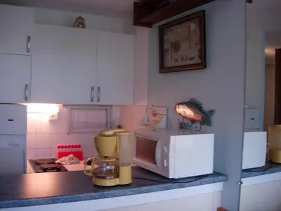 a kitchen with a counter top with a microwave at Gruissan (Aude) Appartement calme, vue sur port de plaisance -Clim, Empl.Parking in Gruissan