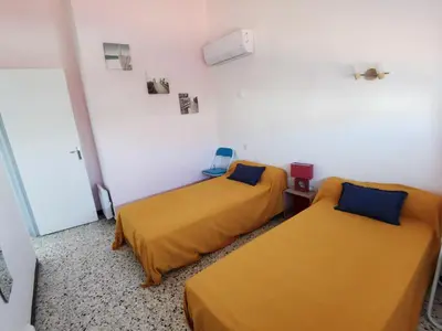 two beds in a room with yellow sheets at Pavillon T3 proche de la plage TERRASSE GARAGE PARKING in Port-la-Nouvelle