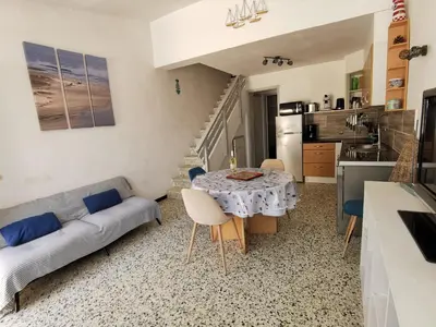 a living room with a table and a couch at Pavillon T3 proche de la plage TERRASSE GARAGE PARKING in Port-la-Nouvelle