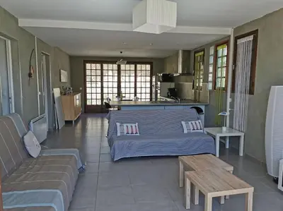 a living room with a bed and a couch at villa plain pied 4 chambres à 100m de la plage in Port-la-Nouvelle