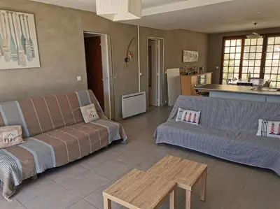 a living room with a couch and a table at villa plain pied 4 chambres à 100m de la plage in Port-la-Nouvelle