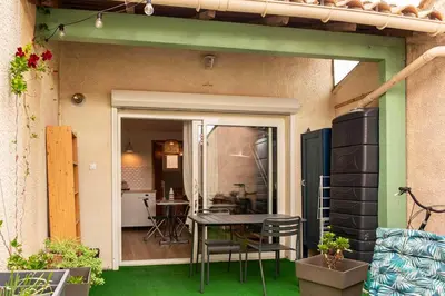 a patio with a table and chairs and a kitchen at Charmant appartement à Sigean - 23 m² - Climatisation in Sigean
