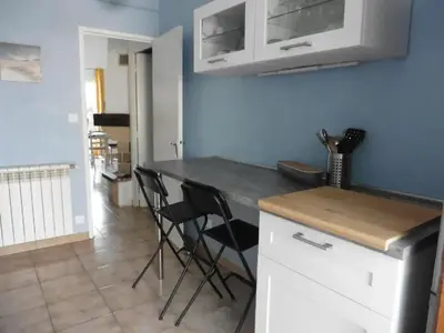 a kitchen with a counter and chairs in a room at Maison avec jardin à Sigean - Confort et tranquillité in Sigean