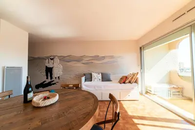 a living room with a table and a couch at Appartement moderne vue mer à Port-la-Nouvelle — 42 m² in Port-la-Nouvelle