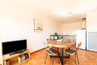 a living room with a dining room table and a television at Appartement moderne vue mer à Port-la-Nouvelle — 42 m² in Port-la-Nouvelle