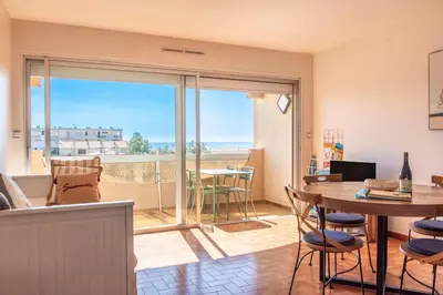 a living room with a table and a view of the ocean at Appartement moderne vue mer à Port-la-Nouvelle — 42 m² in Port-la-Nouvelle