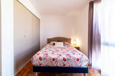 a bedroom with a bed with a floral bedspread at Appartement moderne vue mer à Port-la-Nouvelle — 42 m² in Port-la-Nouvelle