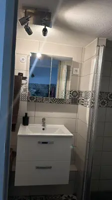 a bathroom with a white sink and a mirror at Chez BEN avec tout le confort clim wifi Netflix gratuit in Castres