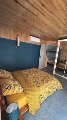 a bedroom with a bed and a blue wall at Chez BEN avec tout le confort clim wifi Netflix gratuit in Castres