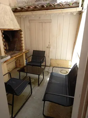two chairs and a table in a room with a fireplace at La Maison de Chouquette in Limoux