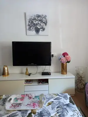 a living room with a tv on a white table at La Maison de Chouquette in Limoux
