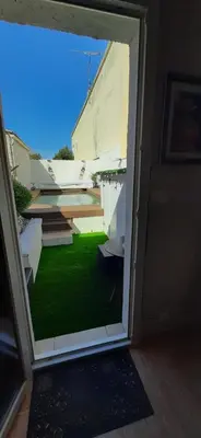 a door with a view of a room with green grass at Chambre spacieuse, indépendante, 700m de la gare in Narbonne