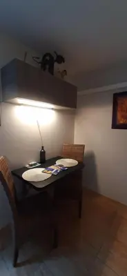 a table with chairs and a light in a room at Chambre spacieuse, indépendante, 700m de la gare in Narbonne