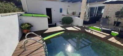 a small swimming pool on a patio with a wooden deck at Chambre spacieuse, indépendante, 700m de la gare in Narbonne