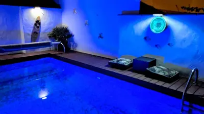 a large swimming pool with a blue lighting in a house at Chambre spacieuse, indépendante, 700m de la gare in Narbonne