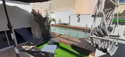 a patio with a hammock and a swimming pool at Chambre spacieuse, indépendante, 700m de la gare in Narbonne