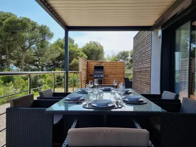 a table on a balcony with a table and chairs at Cottage du Lac 63 in Olonzac