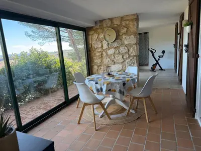 a large kitchen with white cabinets and a window at Grand T2 bis avec terrasse et vue in Portel-des-Corbières