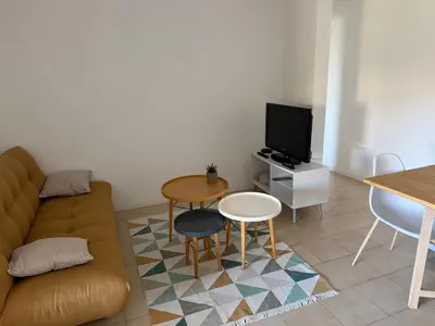 a living room with a couch and a table at Grand T2 bis avec terrasse et vue in Portel-des-Corbières