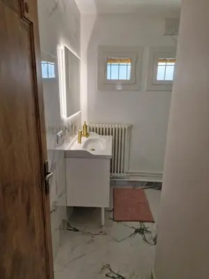 a white bathroom with a sink and a mirror at Villa BEETHOVEN in Carcassonne