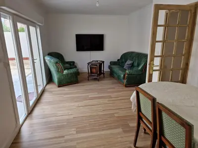 a living room with two green chairs and a television at Villa BEETHOVEN in Carcassonne