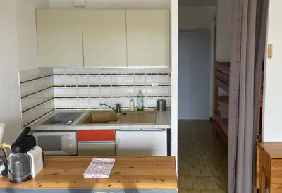 a small kitchen with a sink and a stove at Vue ensoleillée sur le port de Gruissan in Gruissan