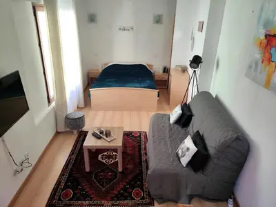 a living room with a couch and a bed at Confortable maison de village en pierre typique in Molitg les Bains