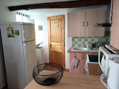 a kitchen with a white refrigerator and a sink at Confortable maison de village en pierre typique in Molitg les Bains
