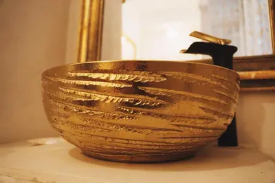 a brown basket sitting on a table in front of a mirror at Maison d'hôtes de charme 