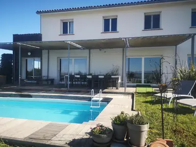 a house with a swimming pool in front of it at Villa avec piscine à débordement vue exceptionnelle in Puéchoursi