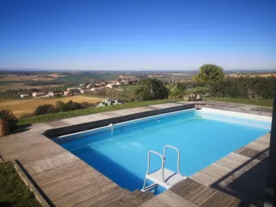 a swimming pool with a view of the countryside at Villa avec piscine à débordement vue exceptionnelle in Puéchoursi