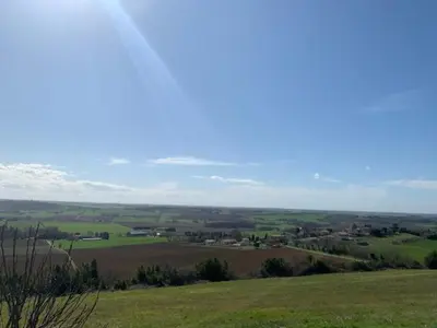 a view of a green field with trees and houses at Villa avec piscine à débordement vue exceptionnelle in Puéchoursi