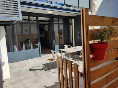 a patio with a table and chairs and a plant at La Bastide de Gabin / ConciergerieDameCarcas in Carcassonne