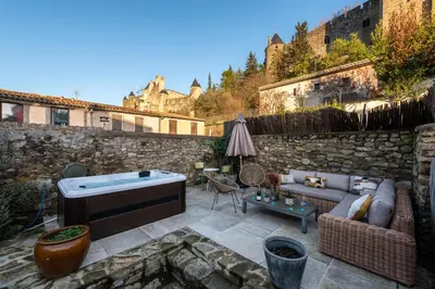a patio with a couch and a hot tub at Au Puits de la Cité - Terrasse Vue Cité - Wifi in Carcassonne
