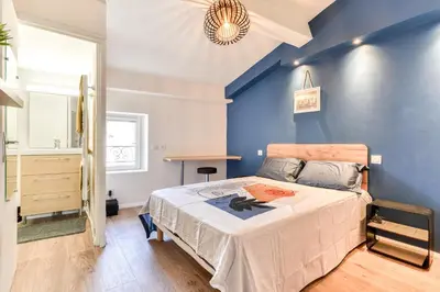 a bedroom with a bed and a blue wall at Côté Palais 2 avec Netflix - Fibre - Proche Cité in Carcassonne
