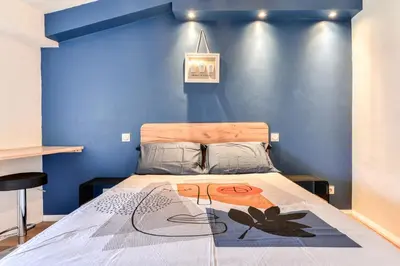 a bedroom with a bed with a blue wall at Côté Palais 2 avec Netflix - Fibre - Proche Cité in Carcassonne