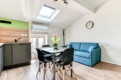 a living room with a table and a blue couch at Côté Palais 2 avec Netflix - Fibre - Proche Cité in Carcassonne