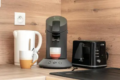 a coffee maker and a cup of coffee on a counter at Côté Palais 2 avec Netflix - Fibre - Proche Cité in Carcassonne
