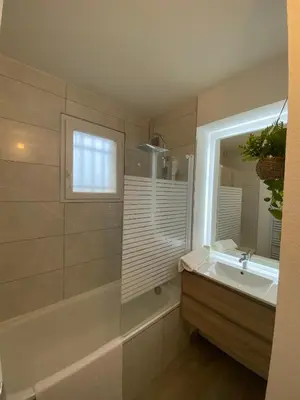 a bathroom with a tub and a sink and a mirror at Appartement cosy, vue imprenable in Carcassonne
