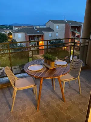a wooden table and chairs on a balcony at Appartement cosy, vue imprenable in Carcassonne