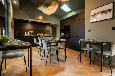 a dining room with black tables and white chairs at La Maison de Jean by Maison Bacou in Carcassonne