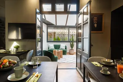 a dining room and living room with a table and chairs at La Maison de Jean by Maison Bacou in Carcassonne