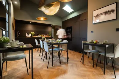 a restaurant with tables and chairs and a man in the background at La Maison de Jean by Maison Bacou in Carcassonne