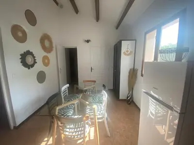 a kitchen with chairs and a table and a refrigerator at Cases des oliviers in Cases-de-Pène