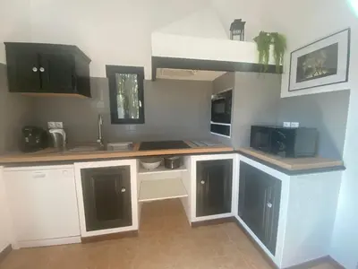 a kitchen with white cabinets and a counter top at Cases des oliviers in Cases-de-Pène