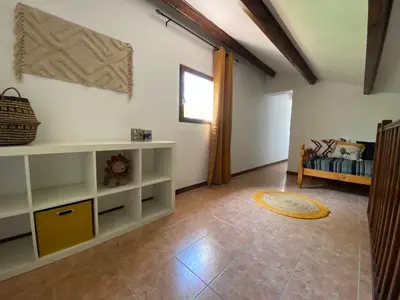 a living room with a white shelf and a bed at Cases des oliviers in Cases-de-Pène