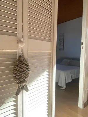 a room with a door with blinds and a bed at Cases des oliviers in Cases-de-Pène